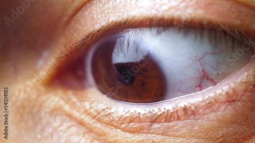 The girl opens her brown eyes wide in surprise. Macro video of the human eye. Woman's eye close up