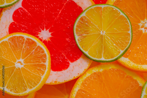 Colorful fresh citrus fruits slices - orange, grapefruit, lemon and lime - close up, top view. Summer, tropical, natural, exotic and healthy food concept