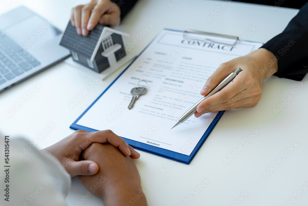 An Asian female sales representative is discussing the details before the customer agrees to sign the contract. By explaining the details and terms and conditions of the rental real estate concept. An Asian female sales representative is discussing the details before the customer agrees to sign the contract. By explaining the details and terms and conditions of the rental real estate concept.