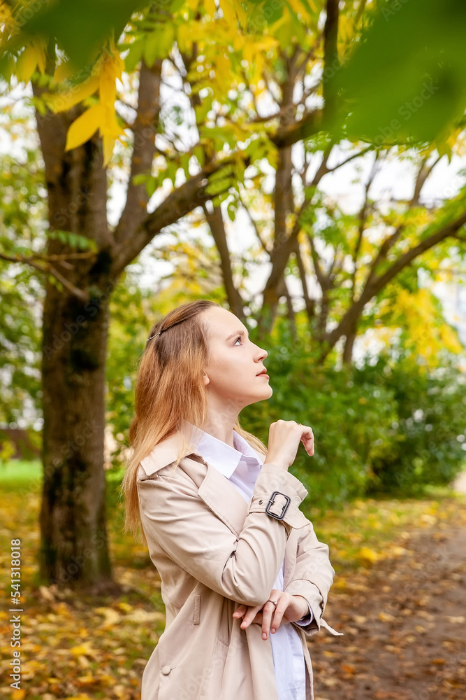 Cute girl on  autumn day against  background of yellow leaves