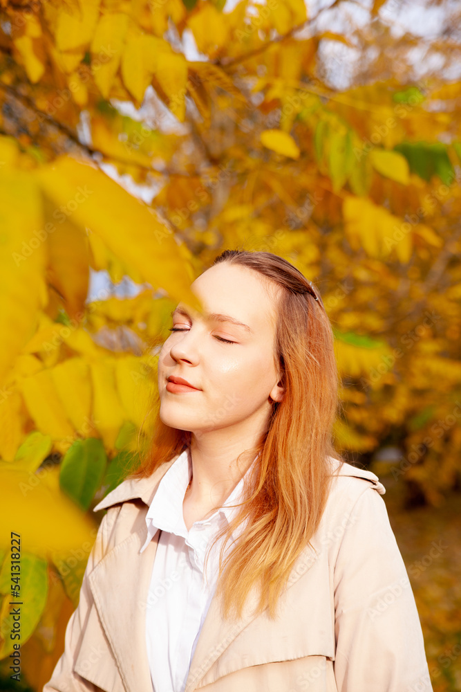 Cute girl on autumn day against background of yellow leaves Cute girl on autumn day against background of yellow leaves