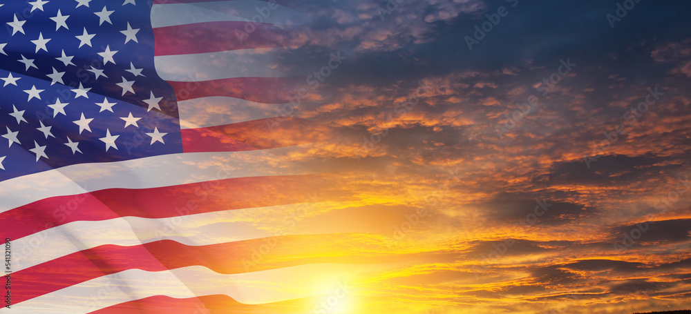 Fototapeta premium United States of America flag on sky at sunset or sunrise background. Independence day, Memorial day, Veterans day. Banner.