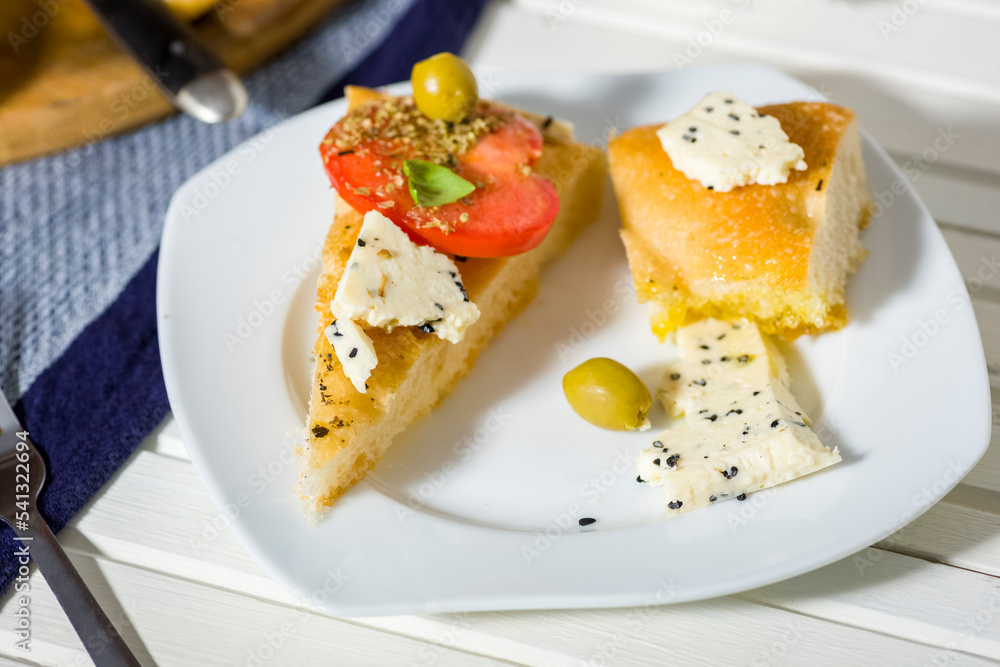 focaccia with tomatoes, cheese, olive oil and other additions focaccia with tomatoes, cheese, olive oil and other additions