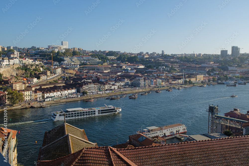 Douro river view scene crossing Oporto city on a blue summer day with some tourist boats cityscape