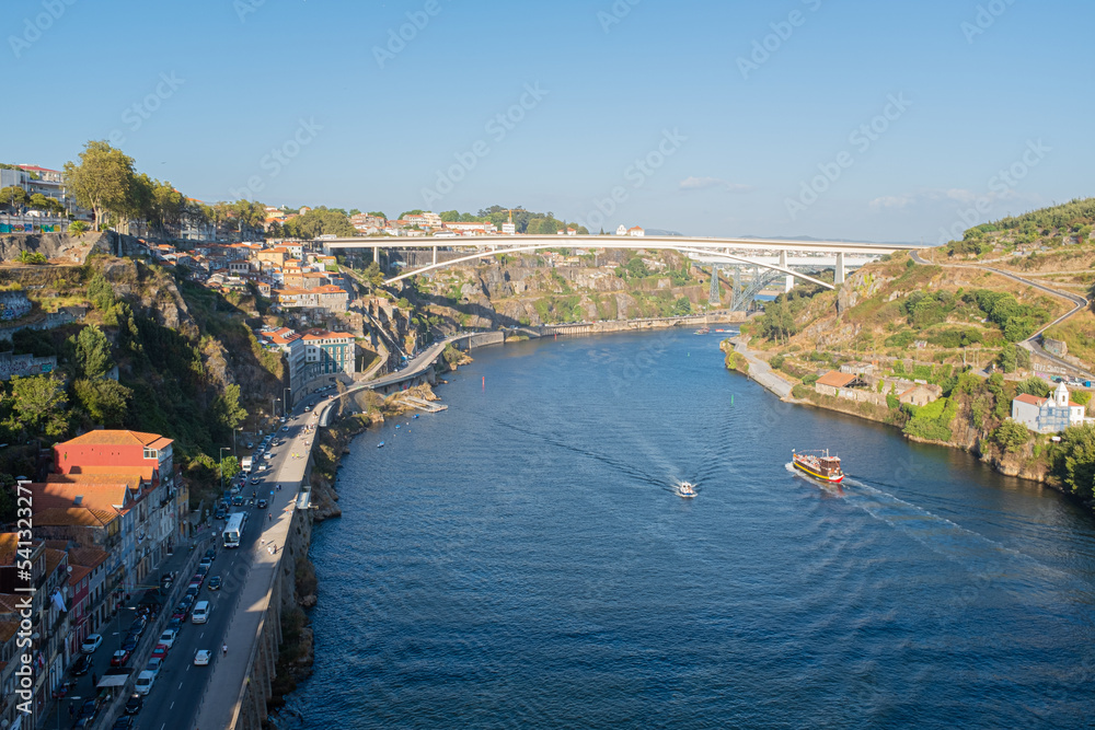 Douro river view scene crossing Oporto city on a blue summer day with some tourist boats cityscape