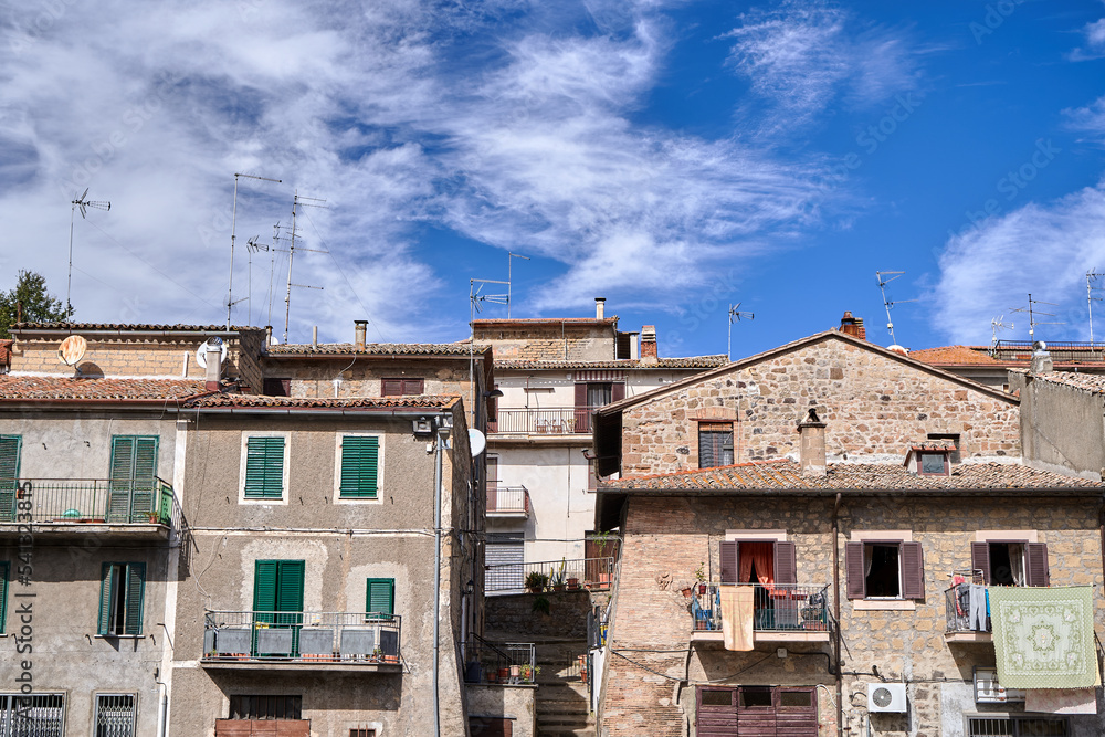 Roofs with antennas and walls with windows and balconies in a small town in Tuscany