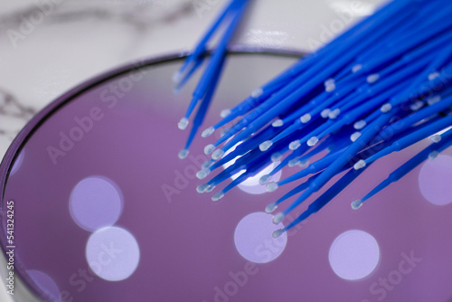 Set of blue microbrushes for eyelashes on a mirror background with bokeh