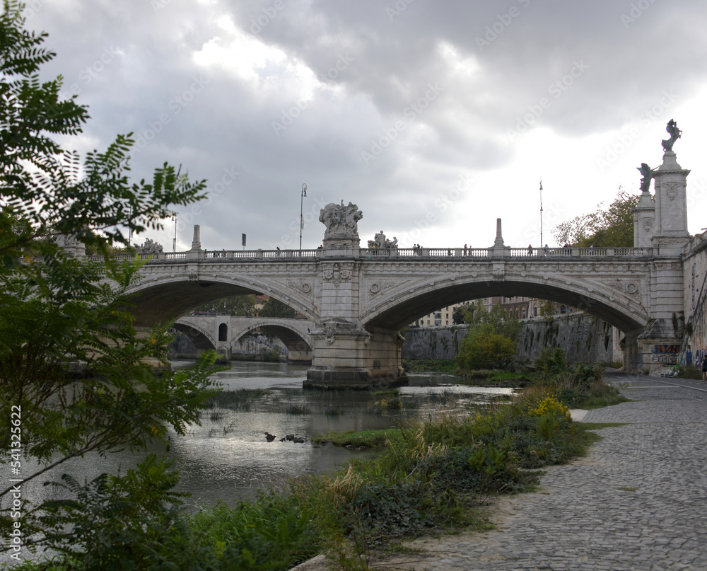 A view of the Saint Angelo bridge during the fall spanning the Tiber river in Rome Italy.
