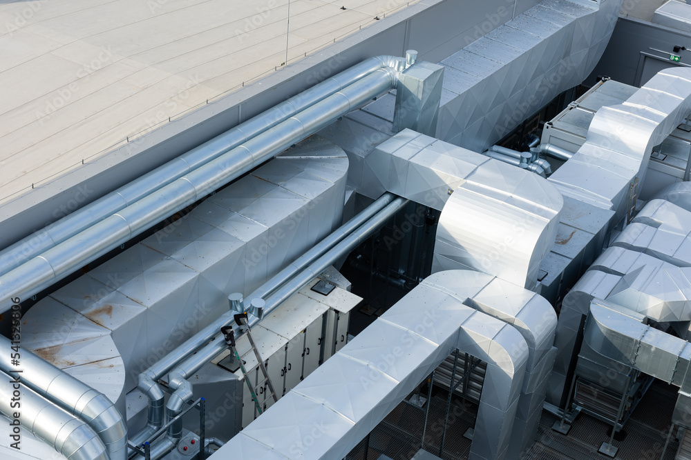 Ducts of the ventilation and air conditioning system on the roof of the building. The photo was taken in natural, soft light. View from above.