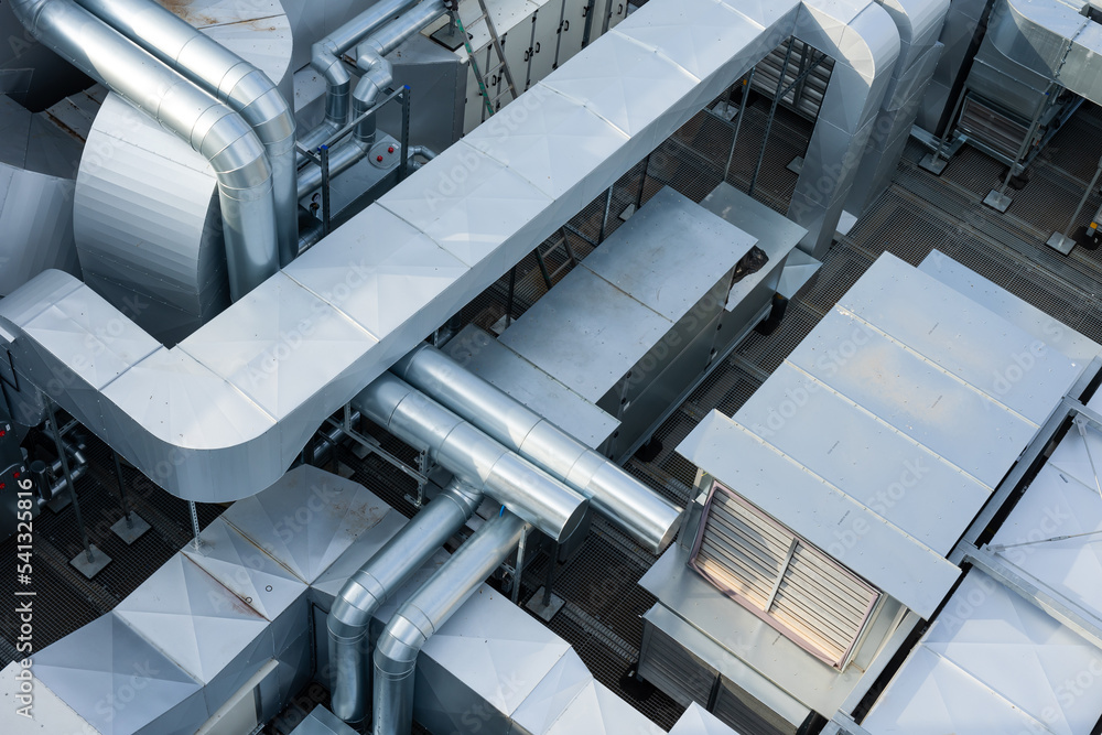Ducts of the ventilation and air conditioning system on the roof of the building. The photo was taken in natural, soft light. View from above.