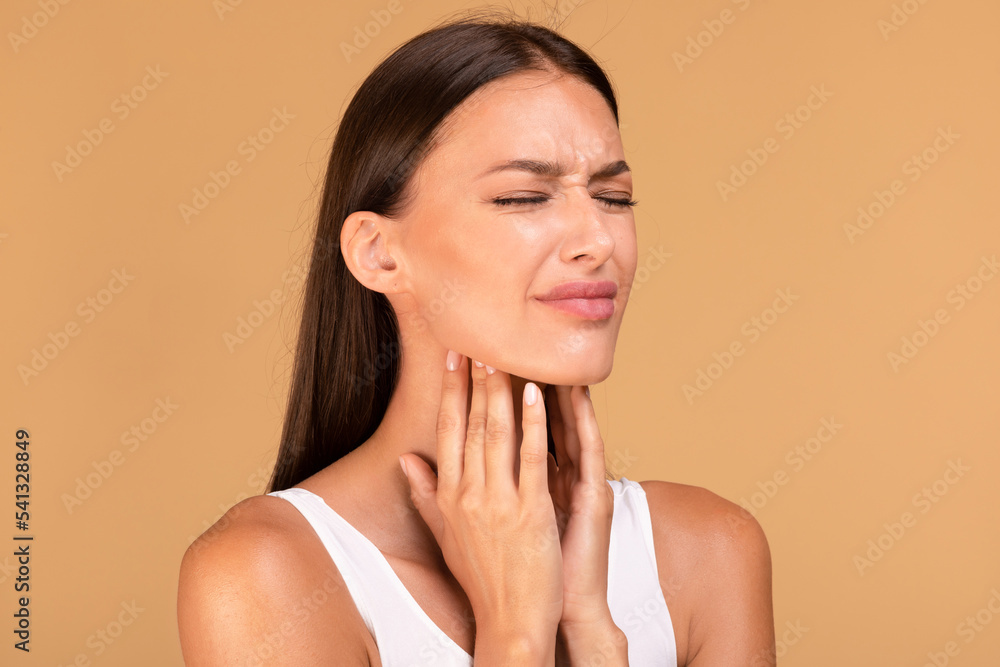 Cold symptoms and medicine concept. Portrait of sick woman suffering from sore throat, ill lady touching neck with hands Cold symptoms and medicine concept. Portrait of sick woman suffering from sore throat, ill lady touching neck with hands