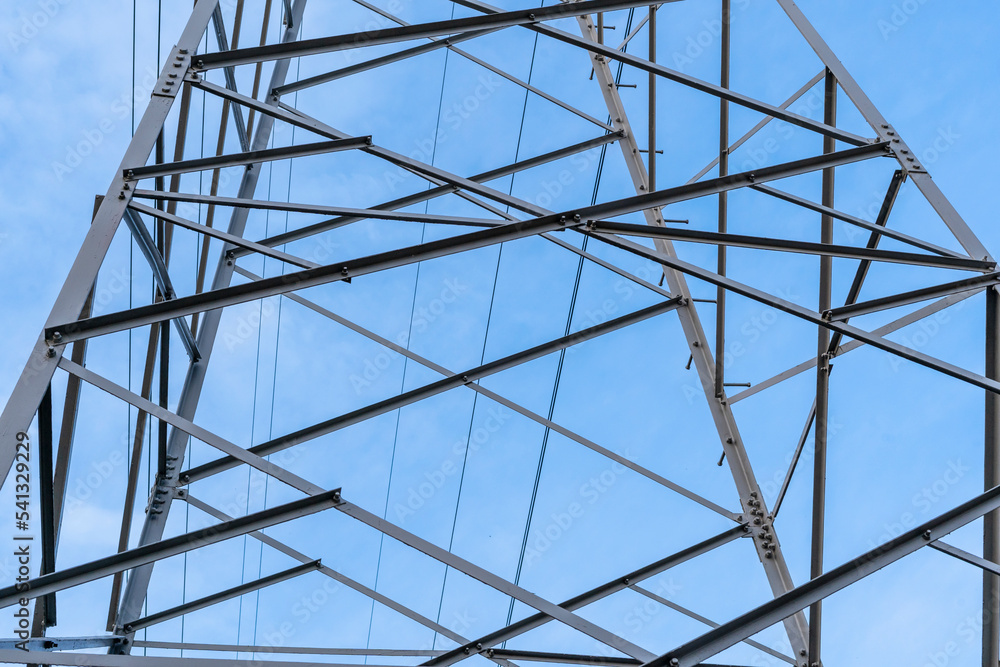 Electric station for supplying electricity to city, village. High voltage electric tower. Close-up. Power line against blue sky. 