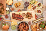 Set of delicious appetizer plates, tapas and grilled chicken and pork ribs, roasted corn, sauces, corn tacos and guacamole