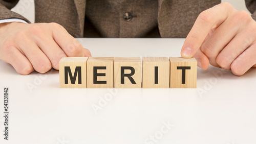 Foto man made word merit with wooden blocks