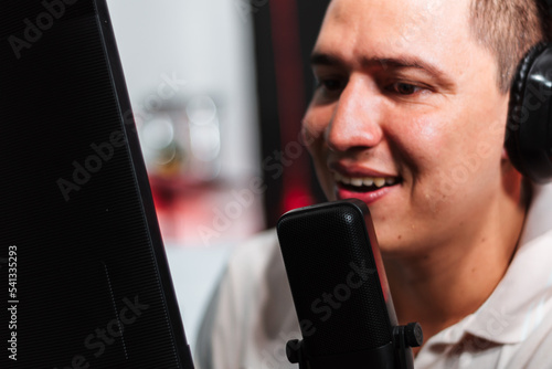 Host Talking and smiling on mic in a stream, podcast show, with headset (headphones) red and black background photo