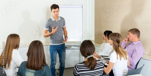 Young businessman presenting new business strategy to his team in modern office.. © JackF