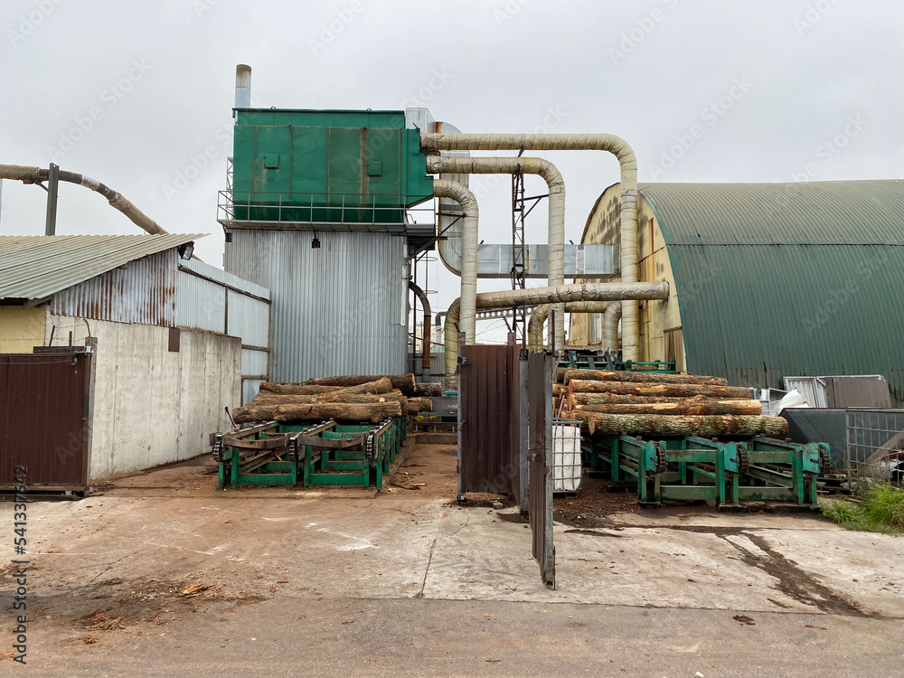 Industrial sawmill with logs for processing into boards, equipment for logging and making wood products
