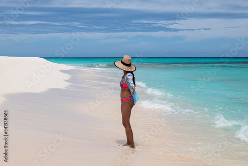 Cayo de Agua (Los Roques Archipelago), Venezuela, 07.30.2022: a young woman in the white beach with crystalline water.