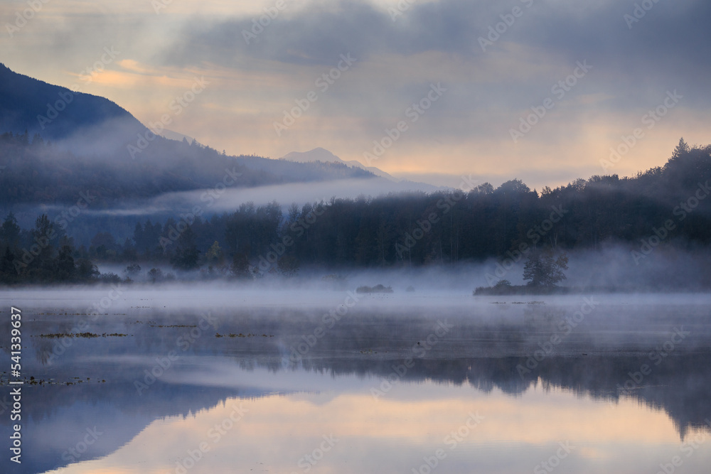 Dramatic fog mist over lake on October morning Dramatic fog mist over lake on October morning