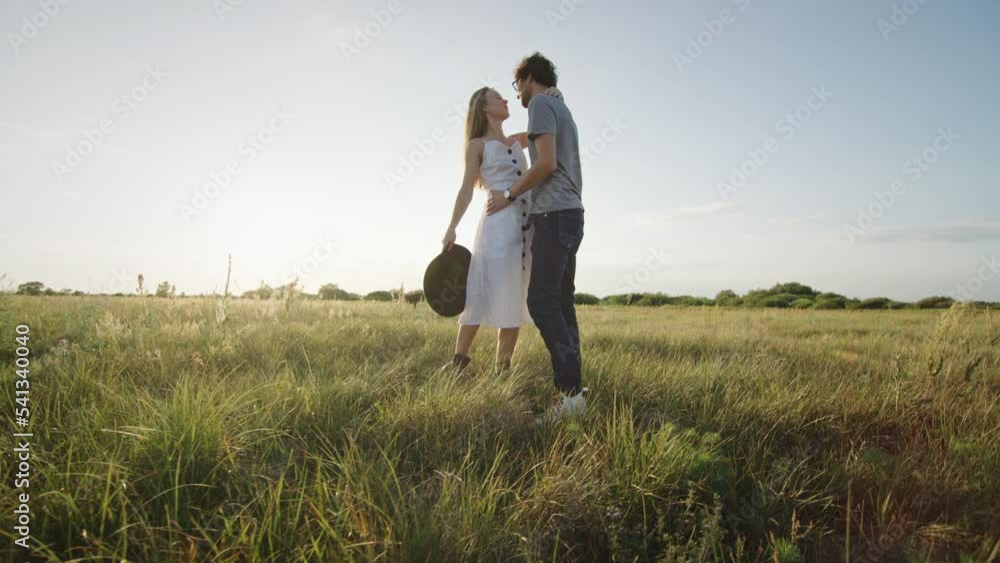Couple spends vacation dancing and kissing against horizon Couple spends vacation dancing and kissing against horizon
