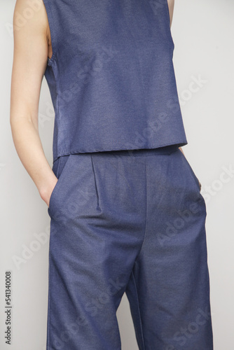 Woman in blue denim blouse and wide pants, studio shot. Denim on denim fashion trend.