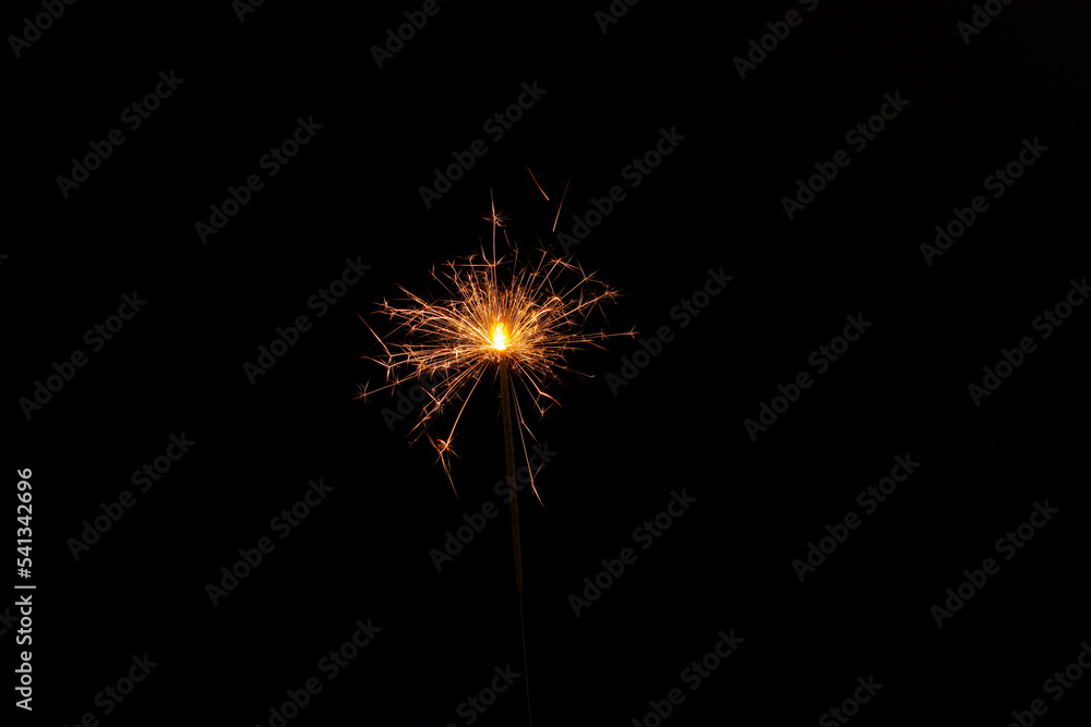 Fototapeta premium One burning sparkler stick on black background