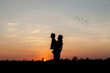 silhouette of a couple walking in the sunset