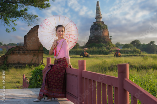 Portrait woman in Thai traeditional. woman in Thai Treaditional red dress with umbrella in Phra Nakhon Si Ayutthaya Historical Park , Thailand. photo