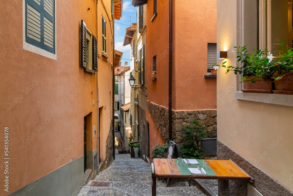 A table for two is set up on a narrow hillside staircase in the historic center of the medieval village of Bellagio, Italy, on the shores of Lake Como.