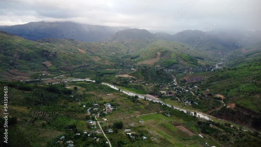 Iconic Vietnam village near river and massive mountains, high altitude aerial Iconic Vietnam village near river and massive mountains, high altitude aerial