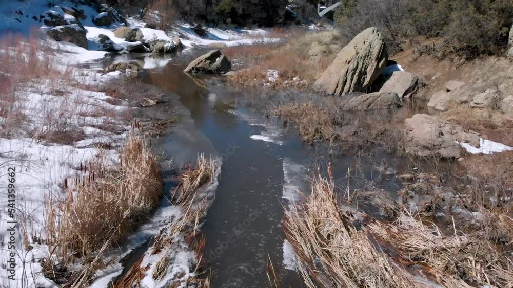 Calm and Tranquil Stream Flowing Through Rocks in Snowy Canyon • Steady Drone Video • HD Horizontal Shot Calm and Tranquil Stream Flowing Through Rocks in Snowy Canyon • Steady Drone Video • HD Horizontal Shot