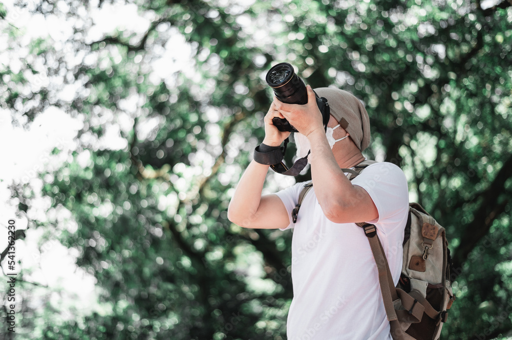 Asian traveler man with backpack taking a photo in the park Asian traveler man with backpack taking a photo in the park
