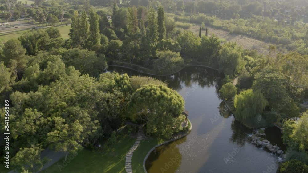 Aerial Forward Shot Of Pond By Trees Over Hill, Drone Moving Forward On Sunny Day - Southern California, California Aerial Forward Shot Of Pond By Trees Over Hill, Drone Moving Forward On Sunny Day - Southern California, California