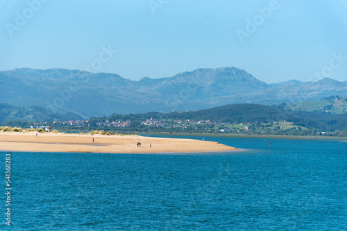 Vista panor  mica a  rea de la bah  a de Santo  a durante la marea baja con el agua del mar en calma y turquesa y la arena blanca durante un d  a soleado con el cielo azul despejado en Cantabria.