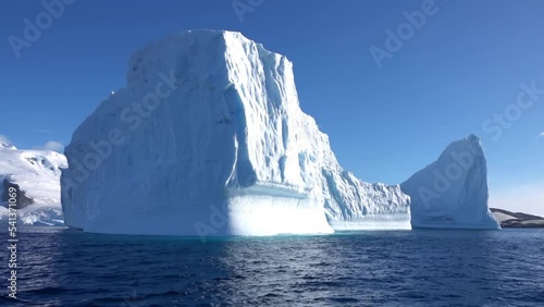 Massive Iceberg chunk in the sea of Antarctica, blue sky
Large chunk of iceberg, South pole, summer august, 2022
 photo