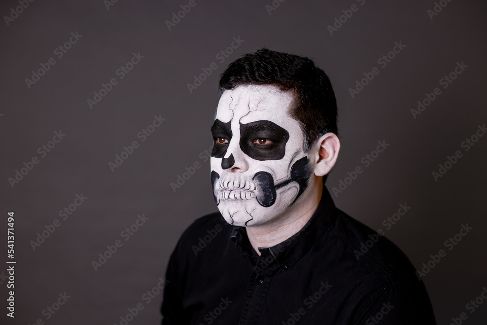 hombre maquillado de catrin o calavera para el dia de muertos como tradición mexicana con cara pintada con el concepto tradicional mexicano
