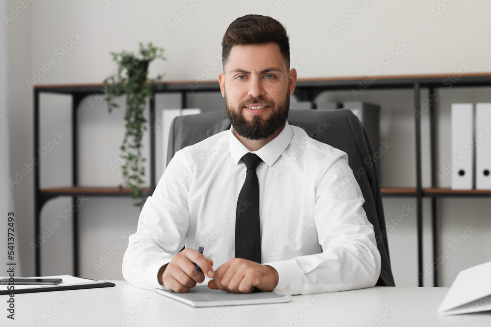 Handsome bank manager at table in office Handsome bank manager at table in office