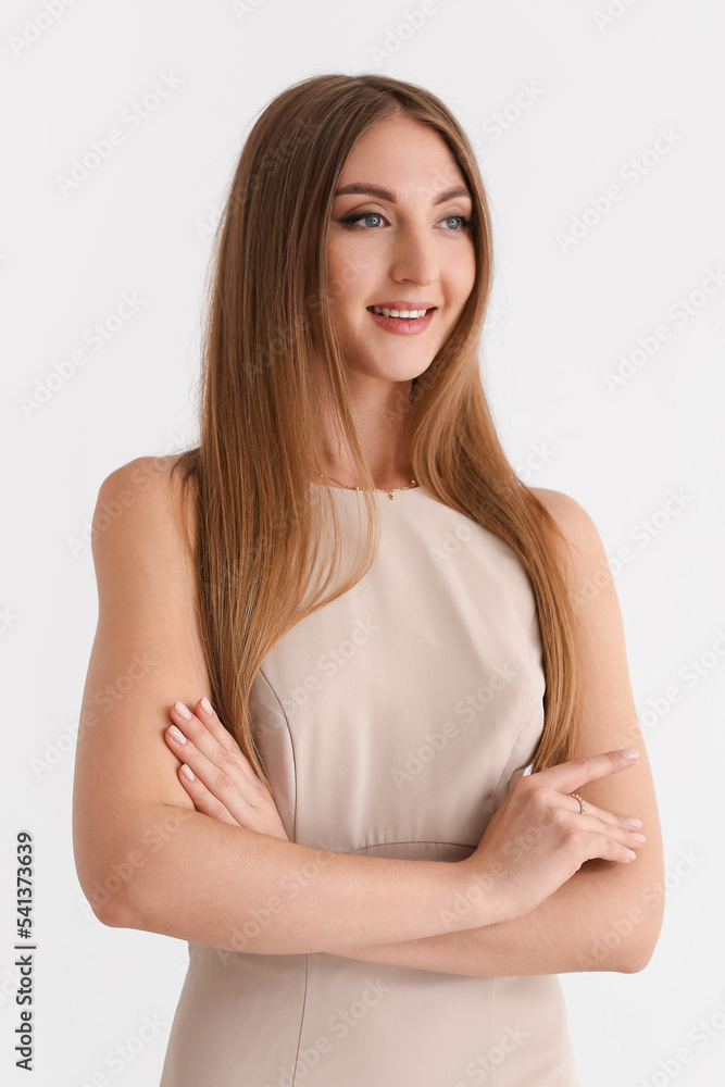 Beautiful fashionable young woman in elegant beige dress on white background Beautiful fashionable young woman in elegant beige dress on white background