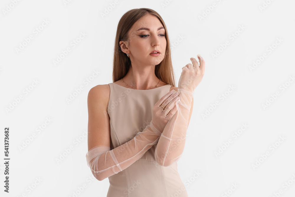 Beautiful fashionable young woman in elegant beige dress on white background Beautiful fashionable young woman in elegant beige dress on white background