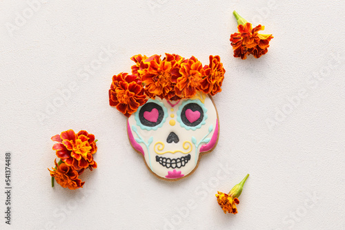 Fototapeta Naklejka Na Ścianę i Meble -  Skull shaped cookie with marigold flowers on white background. El Dia de Muertos
