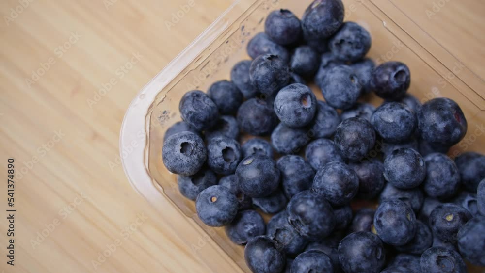 Blueberries dropping into a punnet. Blueberries dropping into a punnet.