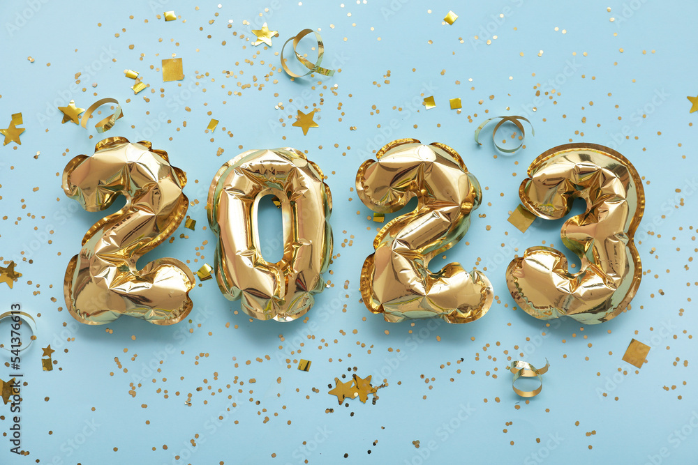 Figure 2023 made of balloons with confetti on blue background Figure 2023 made of balloons with confetti on blue background