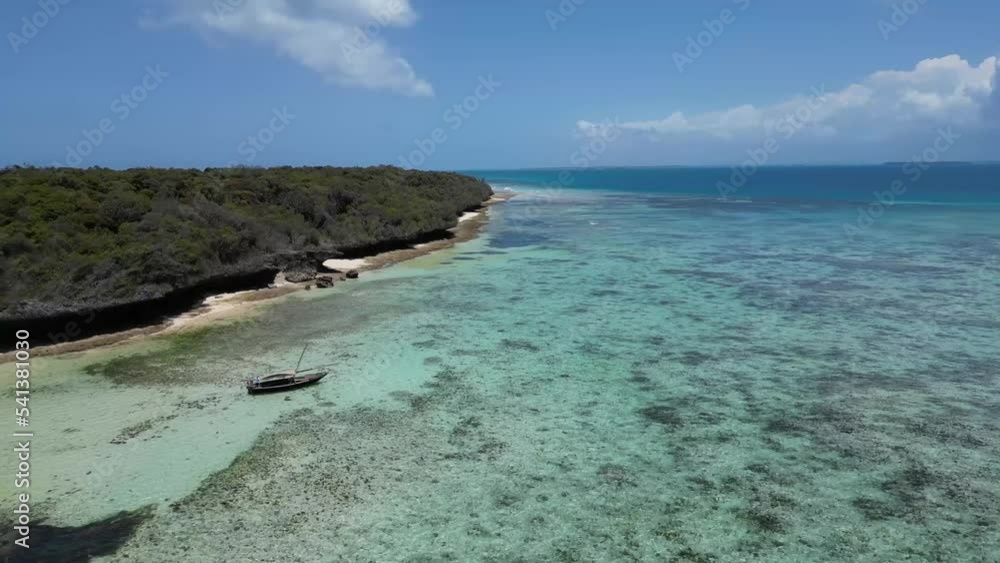 Sailboat floating above the shallow coral lagoon in Pungume Island Tanzania Africa southern Zanzibar, Aerial right rising shot Sailboat floating above the shallow coral lagoon in Pungume Island Tanzania Africa southern Zanzibar, Aerial right rising shot