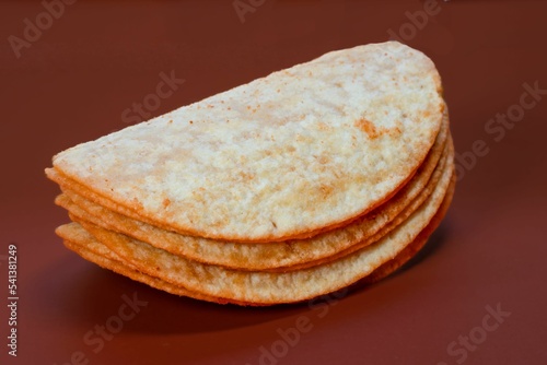 Closeup shot of the stack potatoes chips isolated on dark red background