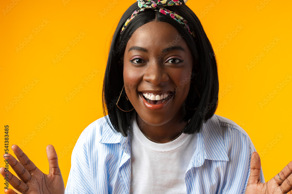 Surprised happy young african woman express shock against yellow background Surprised happy young african woman express shock against yellow background