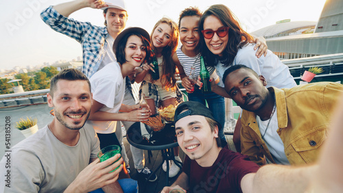 Fotografia Point of view shot of attractive young men and women taking selfie with bottles, enjoying soft drinks, drinking and posing with funny faces