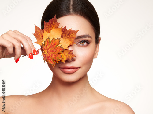 Fotografia Portrait of beautiful young woman with autumn maple leafs