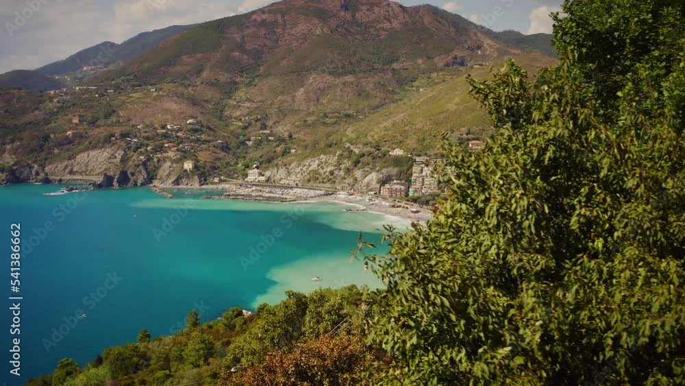 Stunning reveal dolly shot of colorful bay area, coastline and town of Levanto from behind a tree during a lovely, sunny afternoon. Italy, Mediterranean Sea Coast, Europe Stunning reveal dolly shot of colorful bay area, coastline and town of Levanto from behind a tree during a lovely, sunny afternoon. Italy, Mediterranean Sea Coast, Europe
