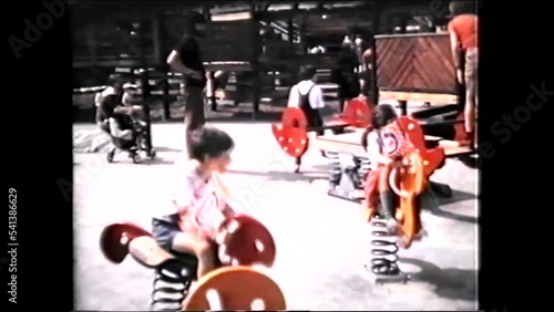 Amusement Park, Children playing on Playground Spring Rockers - 1970s vintage video 8mm photo