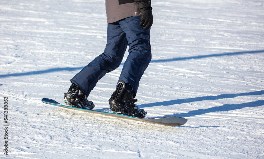 A man slides down the mountain on a snowboard in the snow. A man slides down the mountain on a snowboard in the snow.
